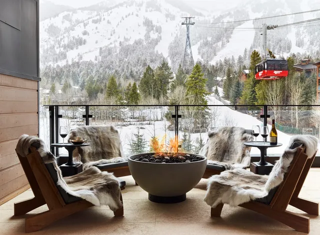 chairs surrounding a fire pit near a mountain
