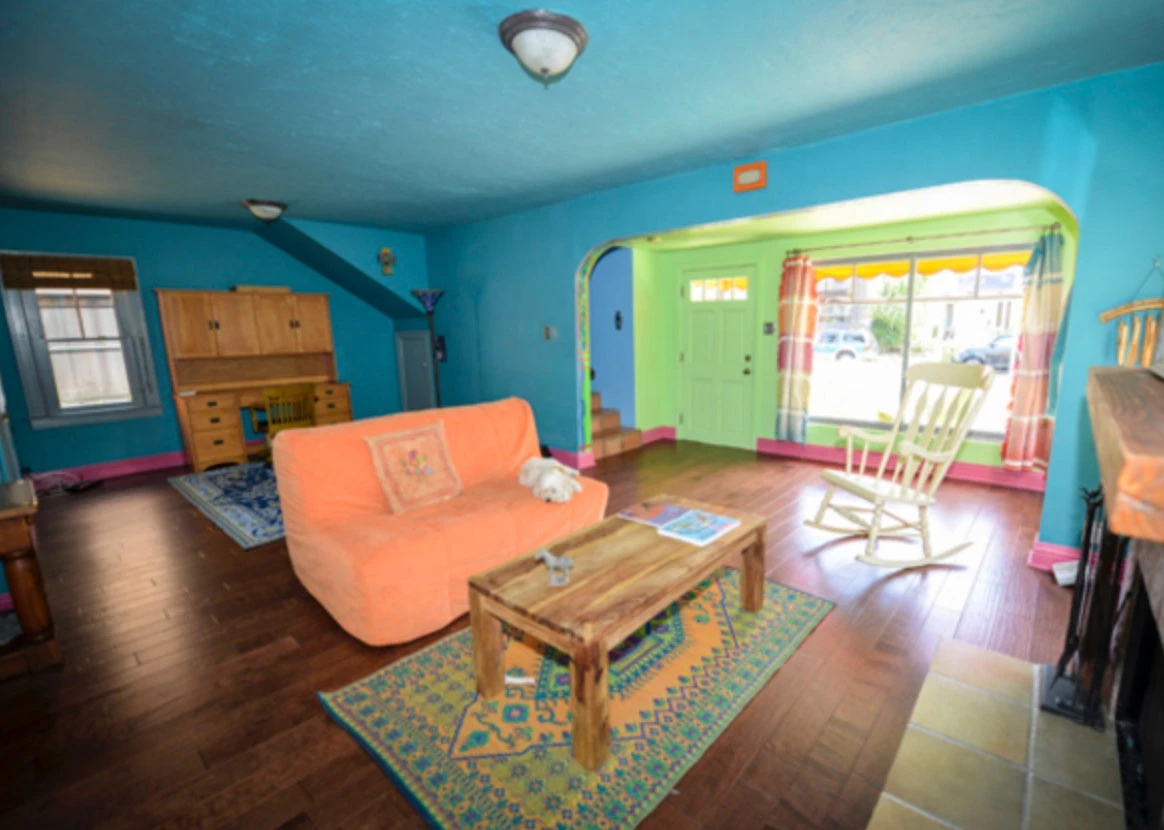 This image may contain Room Indoors Flooring Furniture Chair Living Room Couch Interior Design Wood Rug and Table