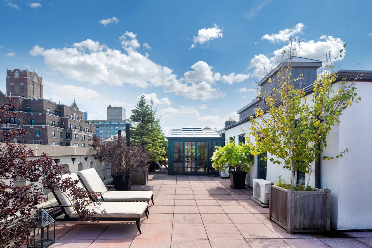 Two lounge chairs on an outdoor terrace.
